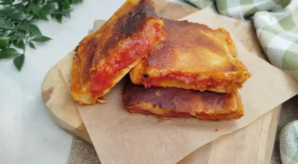 Une parigina napoletana dorée et croustillante, garnie de sauce tomate et de fromage fondant, prête à être dégustée.