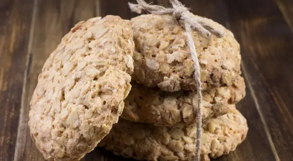 Biscuits aux flocons d'avoine, liés par une ficelle, sur fond de bois. Parfait pour une recette flocon d'avoine maison.