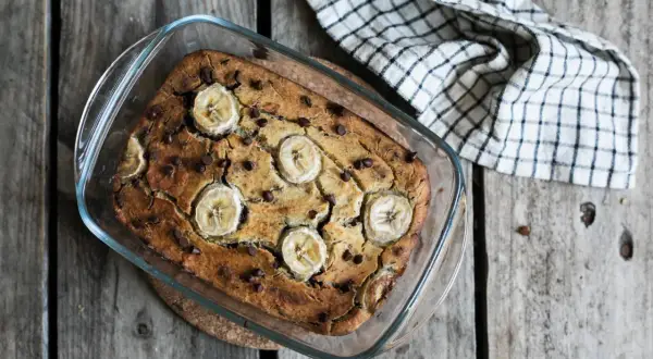 Un délicieux banana bread sans gluten, garni de rondelles de banane et de pépites de chocolat, sort tout juste du four.