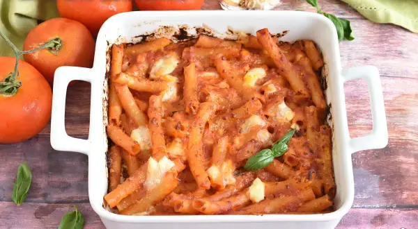 Un plat de rigatoni alla sorrentina gratiné, avec des tomates fraîches et du basilic. Un délice italien réconfortant.
