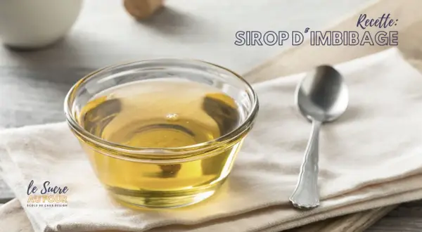 Un bol de sirop d'imbibage doré, parfait pour une génoise moelleuse. Une cuillère repose à côté.