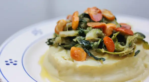 Purée crémeuse surmontée de fave et cicoria, un plat végétarien savoureux.