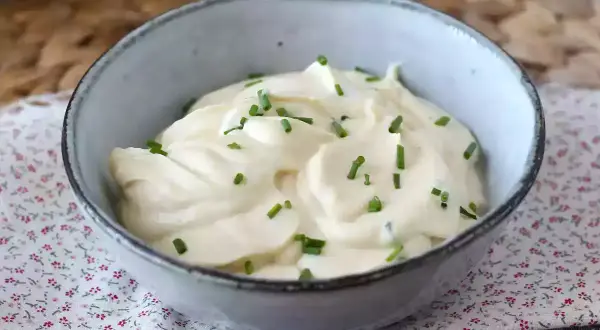 Un bol de mayonnaise sans huile, onctueuse et garnie de ciboulette fraîche. Parfaite pour accompagner vos plats.