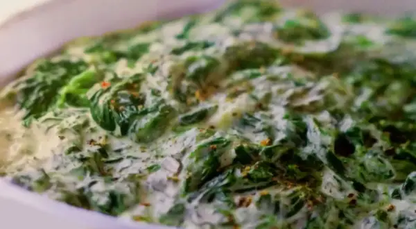 Un plat réconfortant d'épinards à la crème, parsemé d'épices, prêt à être dégusté.