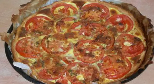 Tarte tomate thon moutarde dorée, garnie de rondelles de tomates fraîches et d'herbes. Un délice croustillant.