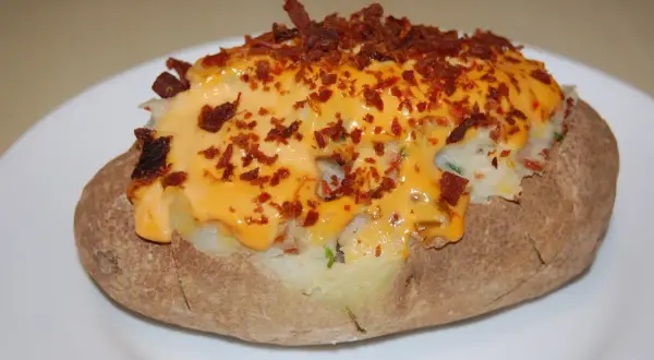 Pommes de terre farcies, généreusement garnies de fromage fondu et de bacon croustillant. Un délice réconfortant.