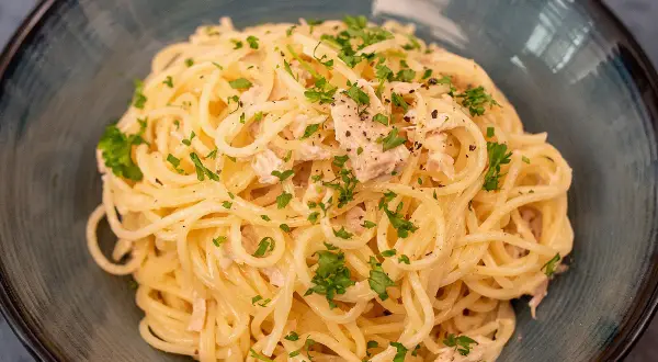 Délicieuses pâtes au thon, une recette simple et savoureuse, garnie de persil frais et de poivre noir.