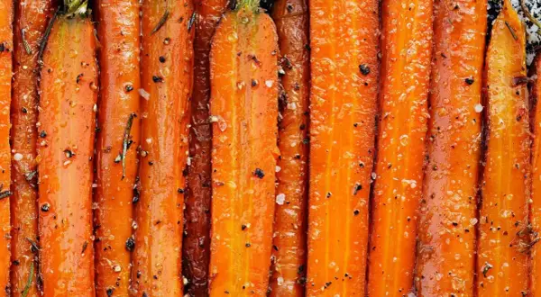 Carottes entières, caramélisées et assaisonnées de sel et de poivre, prêtes à être dégustées. Un délice de carotte à la poêle.