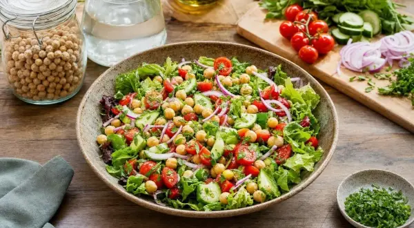 Salade composée fraîche et colorée avec pois chiches, tomates cerises, concombre et oignons rouges. Un délice sain et léger.