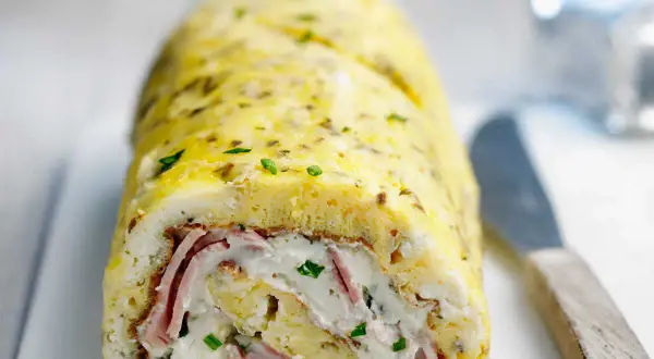 Une savoureuse omelette roulée au four, garnie de jambon et de fromage frais, parsemée de ciboulette. Un délice !