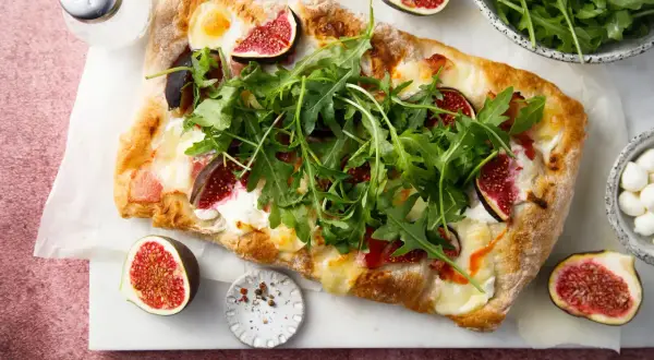 Découvrez 15 recettes étonnantes à la figue fraîche : une pizza gourmande garnie de figues, roquette et mozzarella.