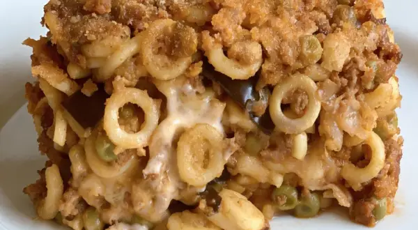 Un plat d'annelletti al forno, avec des pâtes en anneaux, de la viande hachée, des petits pois et du fromage fondant, le tout gratiné.