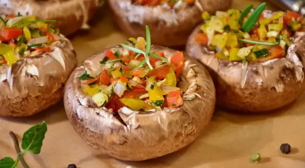 Champignons farcis aux poivrons colorés et herbes fraîches, prêts à être dégustés.