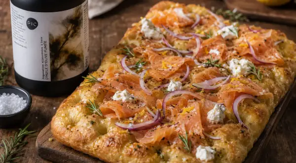 Délicieuse focaccia italiana garnie de saumon fumé, oignons rouges, fromage frais et romarin. Parfait pour un apéritif gourmand.