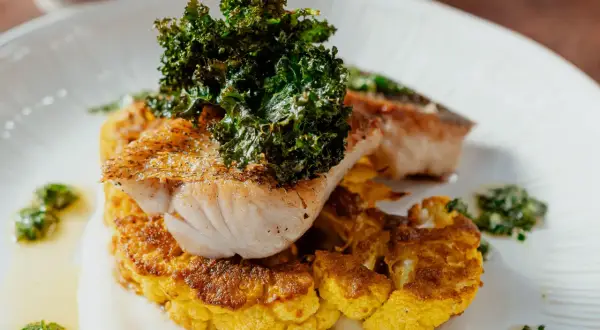 Un délicieux poisson poêlé sur un lit de chou-fleur doré, garni de kale croustillant. Une recette chou-fleur à la poêle qui éveille les papilles.