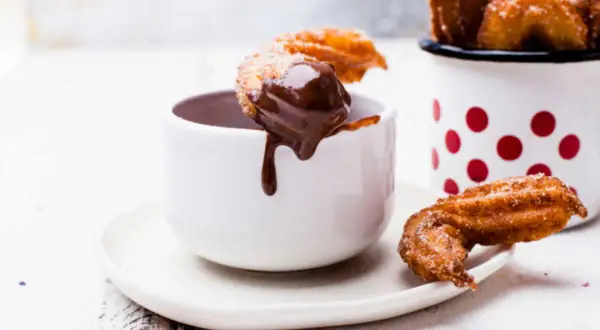 Churros dorés et croustillants, parfaits pour une recette facile à tremper dans un chocolat chaud onctueux.