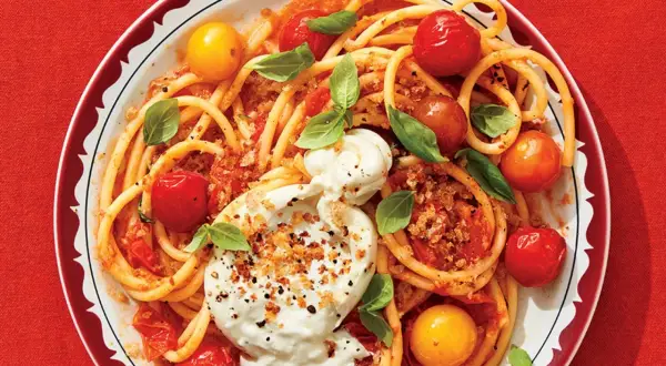 Délicieuse recette de paccheri avec tomates cerises, burrata crémeuse et basilic frais. Un plat coloré et savoureux.