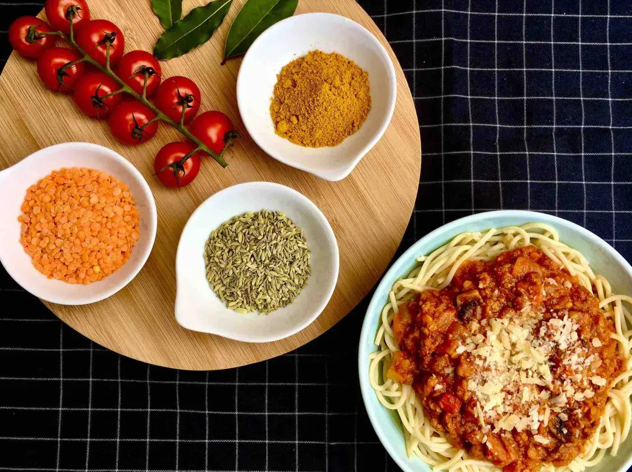 Spaghetti al pomodoro avec lentilles corail, tomates cerises, curcuma et anis étoilé. Un plat savoureux et coloré.