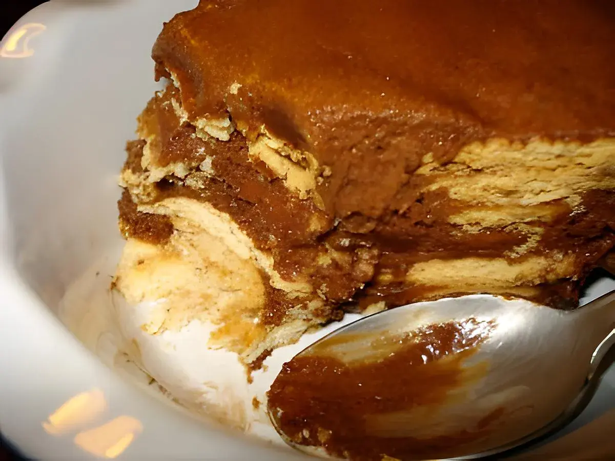 Délicieux gâteau sans cuisson aux couches de biscuits et de crème au chocolat, prêt à être dégusté avec une cuillère.