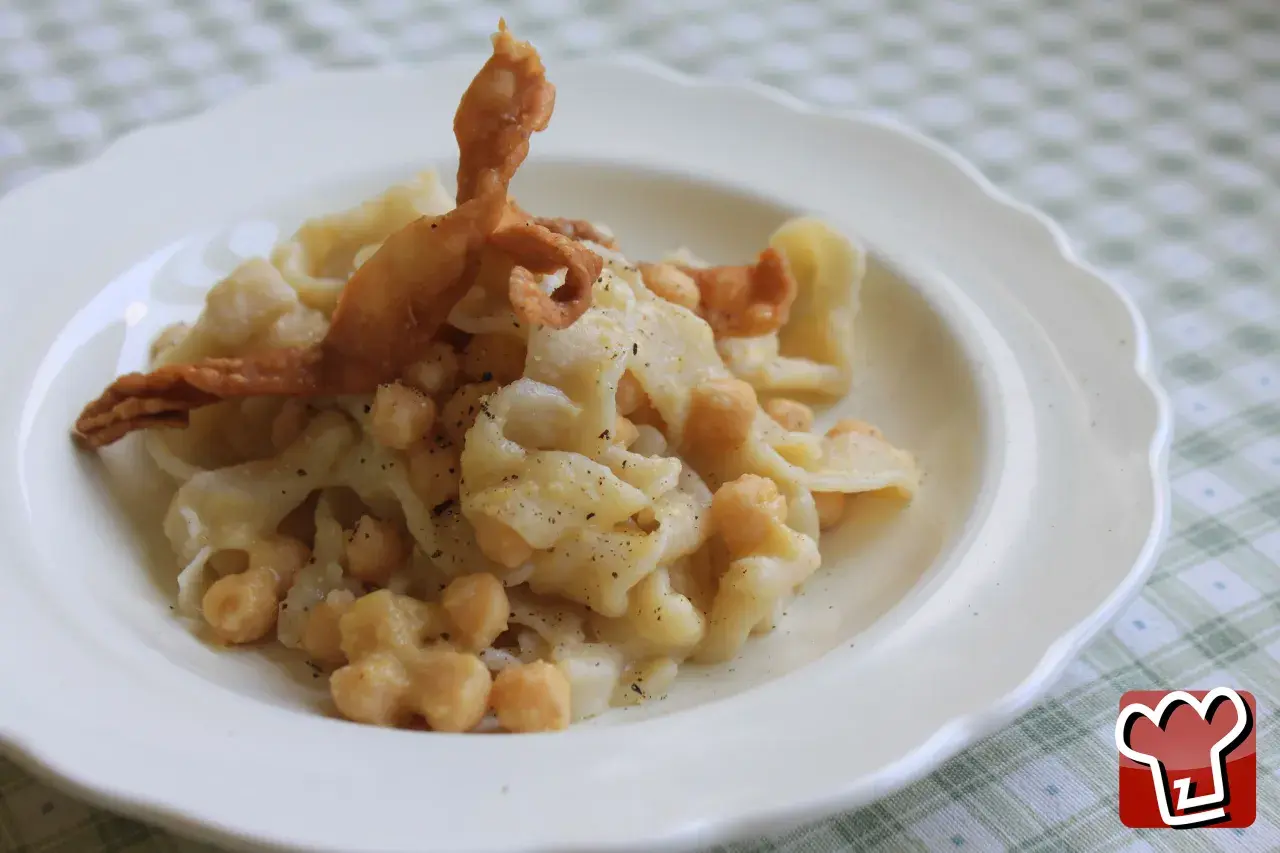 Un plat de ciceri e tria, pâtes fraîches et pois chiches, garni d'une feuille de pâte frite croustillante.