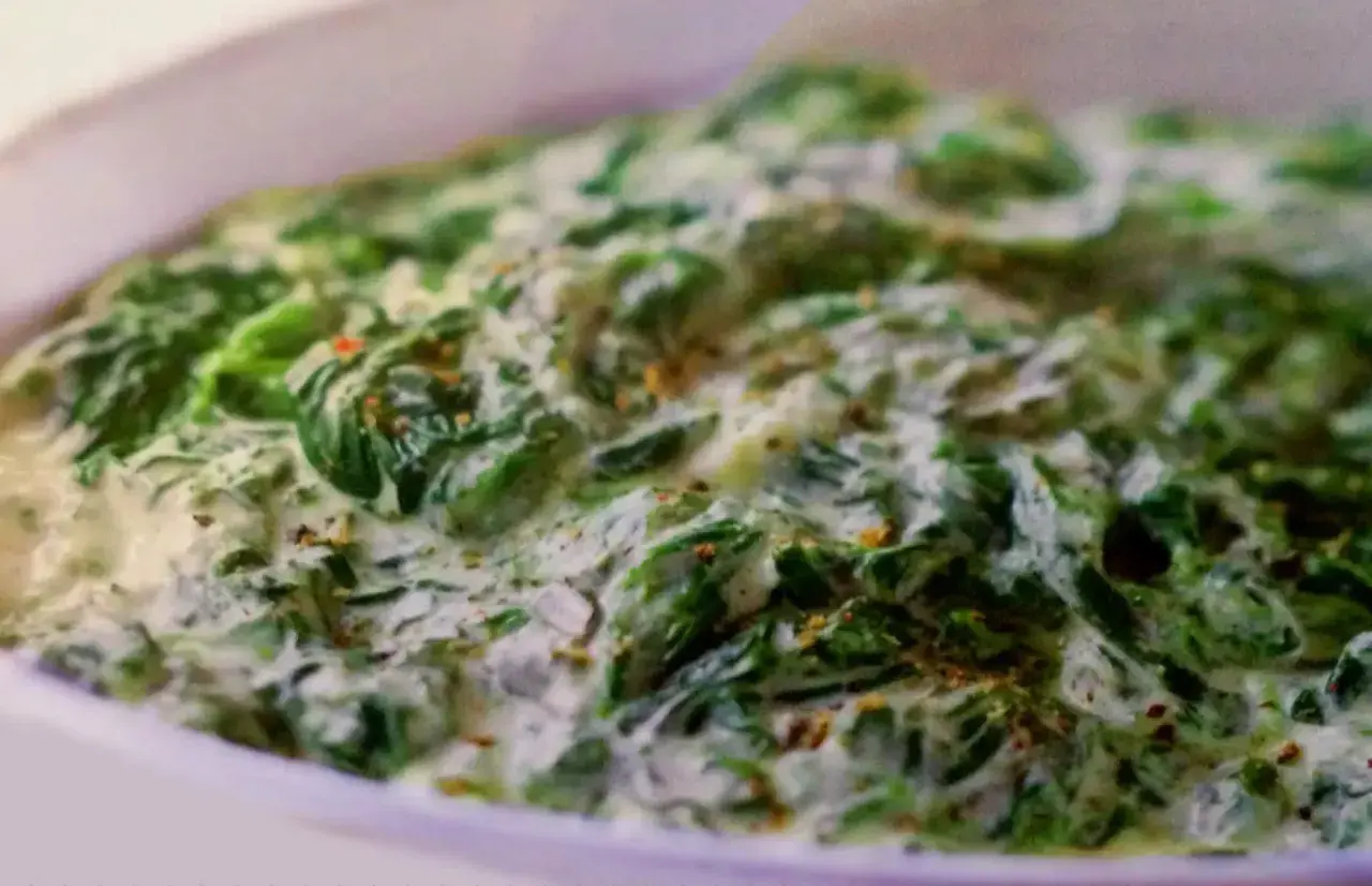 Un plat réconfortant d'épinards à la crème, parsemé d'épices, prêt à être dégusté.