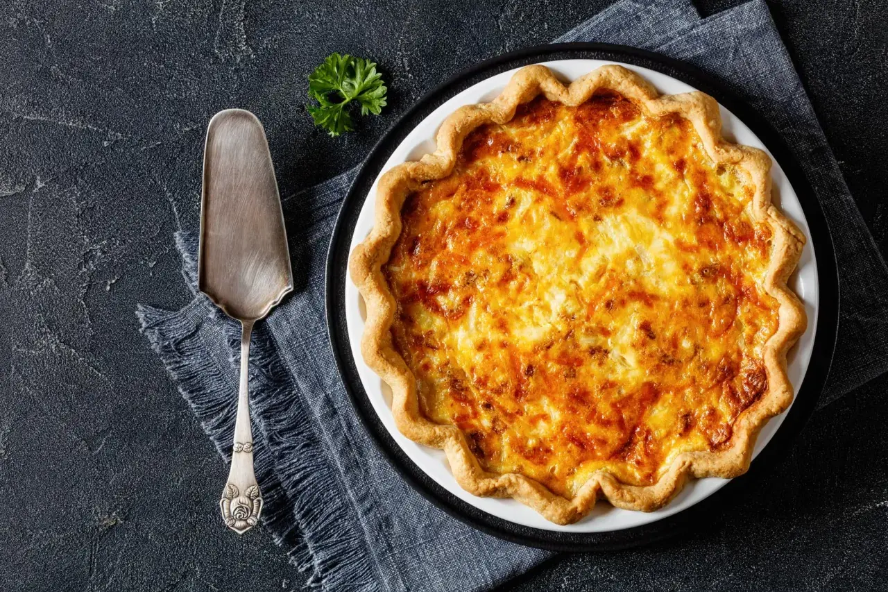 Une délicieuse tarte au fromage dorée, prête à être servie avec une touche de persil.