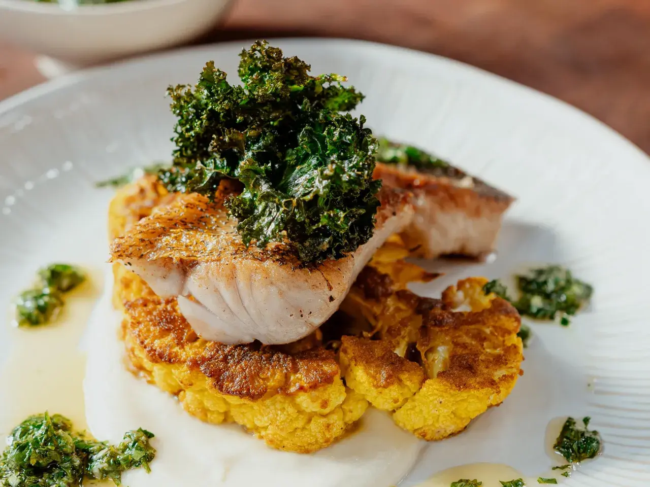 Un délicieux poisson poêlé sur un lit de chou-fleur doré, garni de kale croustillant. Une recette chou-fleur à la poêle qui éveille les papilles.