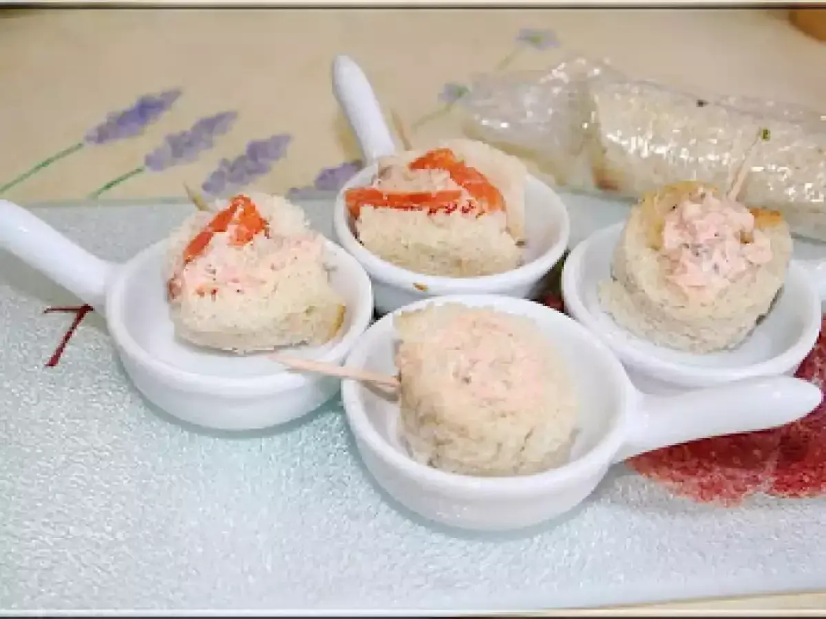 Petites bouchées de pain garnies de rillettes de saumon, présentées dans des cuillères de service.