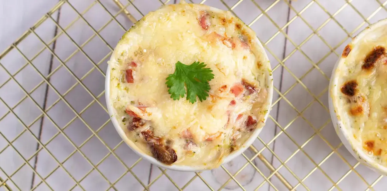 Un gratin de brocolis crémeux et doré, garni d'une feuille de persil, prêt à être dégusté.