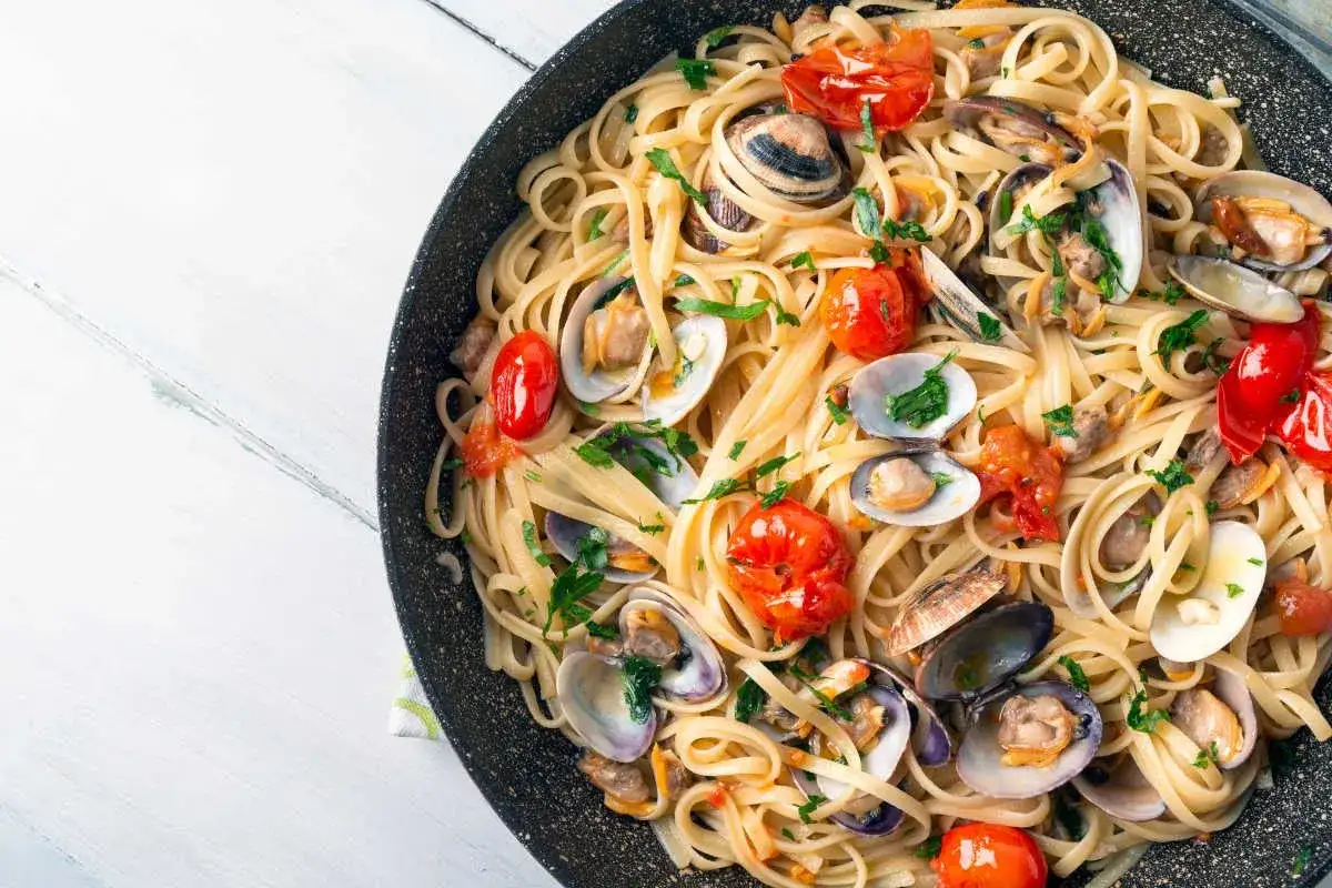 Spaghetti aux fruits de mer, un plat italien savoureux avec des palourdes, des tomates cerises et du persil frais.
