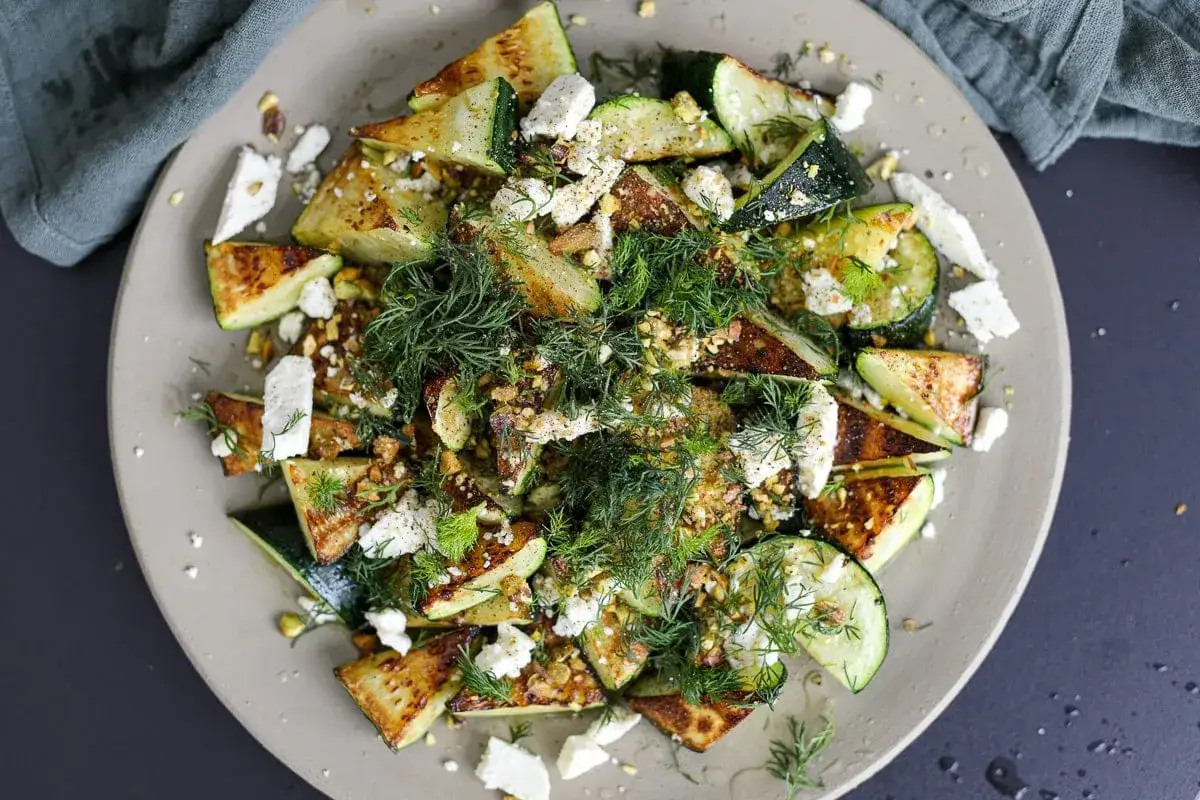 Salade de courgettes grill&eacute;es, feta &eacute;miett&eacute;e, pistaches concass&eacute;es et aneth frais. Une recette courgette simple et savoureuse.