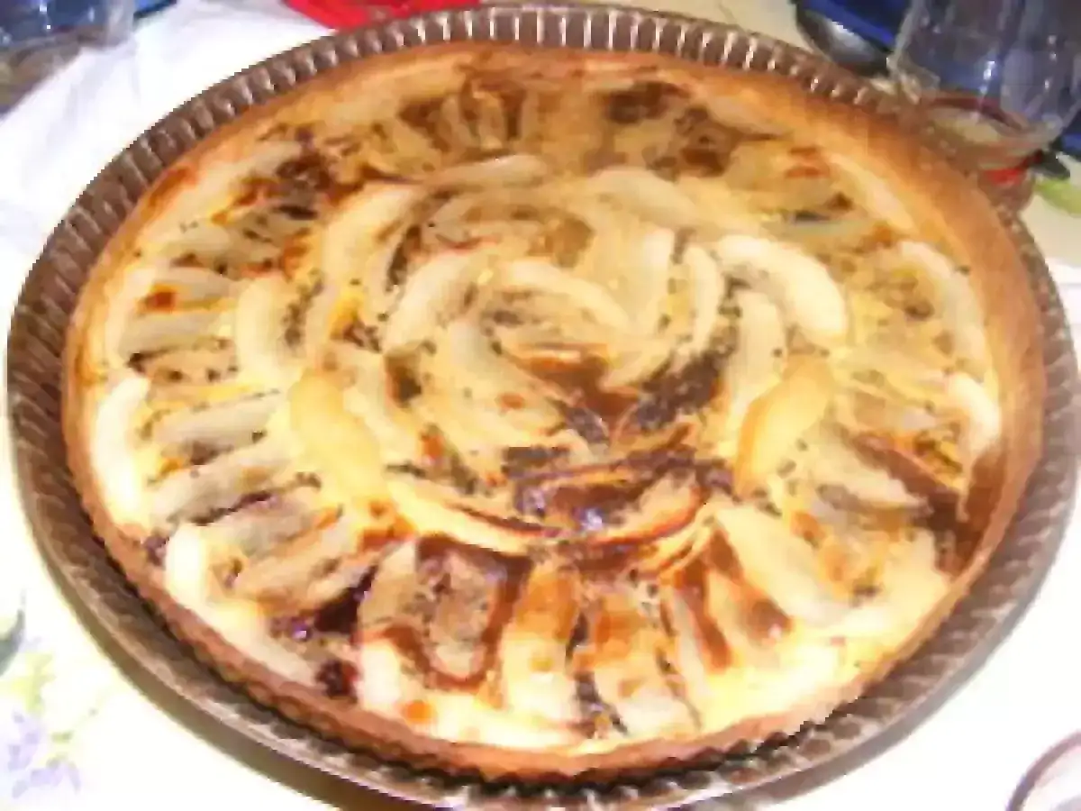 Une délicieuse tarte aux poires, garnie de fruits tendres et d'une crème onctueuse, prête à être dégustée.