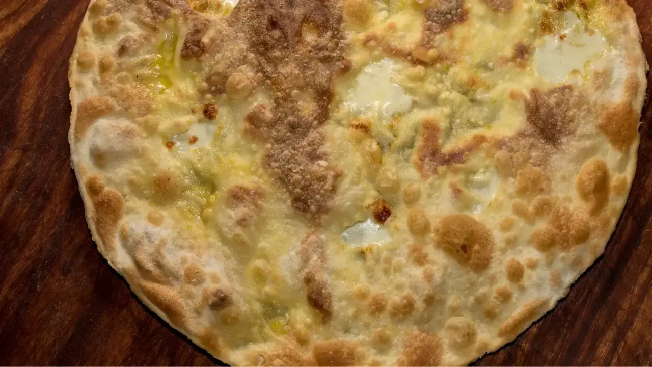 Focaccia di Recco dorée et croustillante, garnie de fromage fondant et d'huile d'olive, prête à être dégustée.