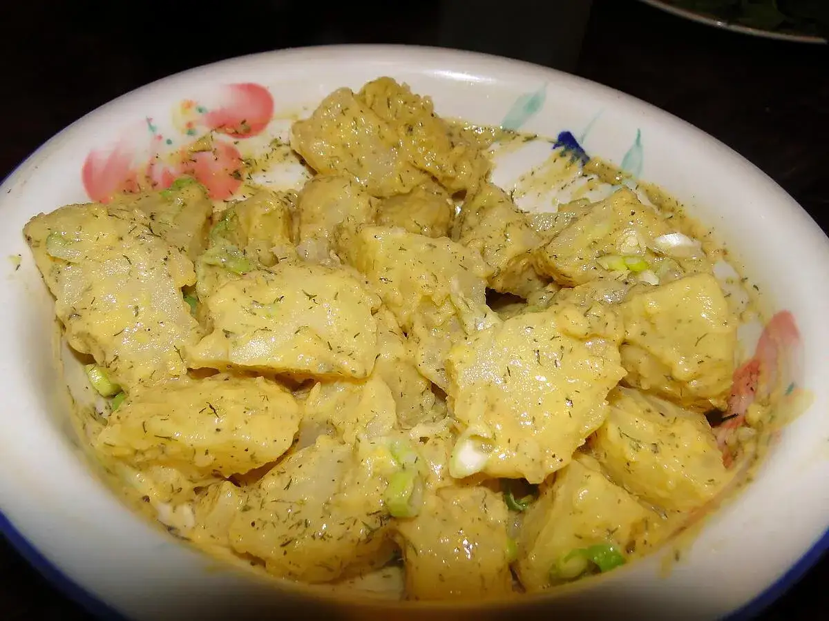 Salade de pommes de terre cr&eacute;meuse, assaisonn&eacute;e de yaourt, moutarde et herbes fra&icirc;ches, servie dans un bol d&eacute;cor&eacute;.