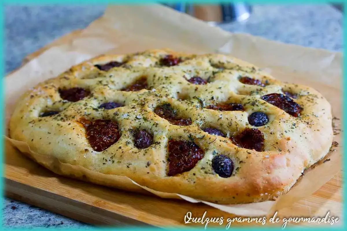 Focaccia italiana dorée, parsemée de tomates séchées, d'olives et d'herbes. Un délice croustillant et moelleux.