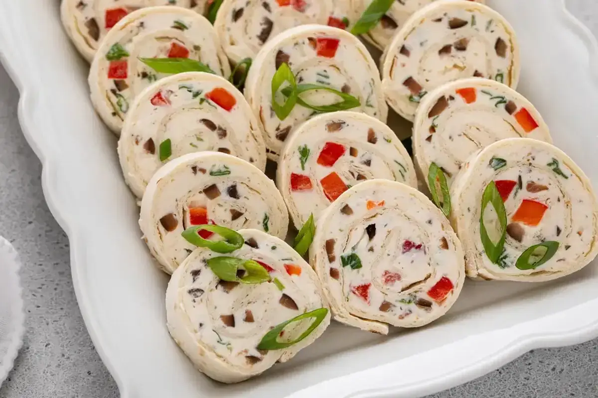 D&eacute;licieux roul&eacute;s de wrap garnis de fromage cr&eacute;meux, poivrons rouges, champignons et ciboule. Parfait pour une recette wrap facile et savoureuse.