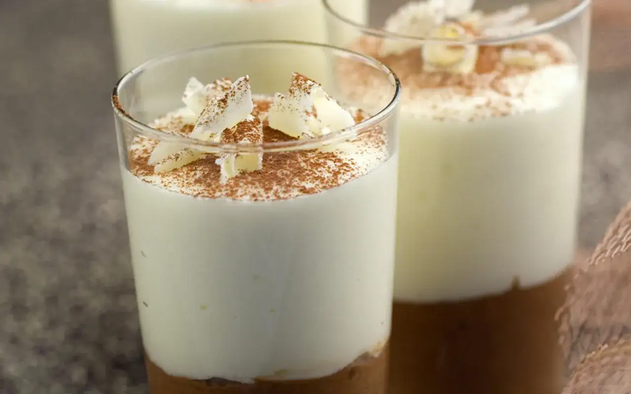 Douce mousse au chocolat blanc aérienne, saupoudrée de cacao et garnie de copeaux de chocolat blanc. Un délice visuel et gustatif.