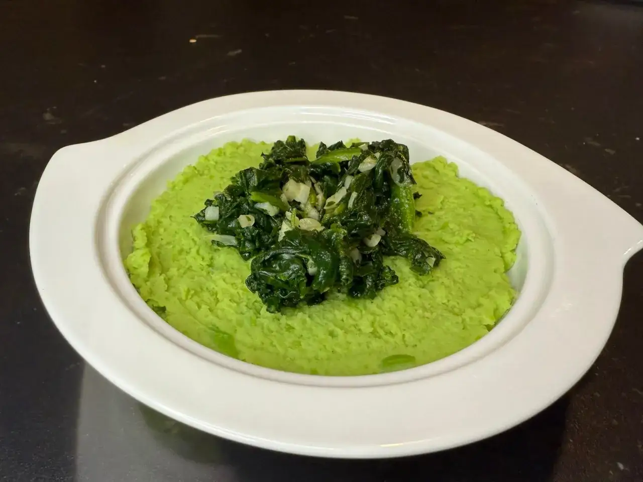 Purée de fèves et cicoria, un plat végétarien coloré et savoureux, servi dans un bol blanc.