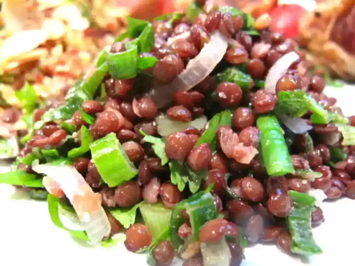 Salade de lentilles savoureuse avec oignons verts et persil frais. Un plat sain et coloré.