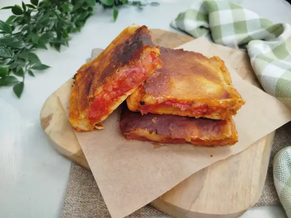 Une parigina napoletana dorée et croustillante, garnie de sauce tomate et de fromage fondant, prête à être dégustée.
