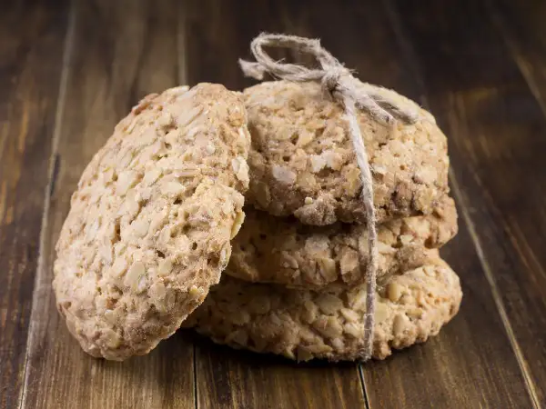 Biscuits aux flocons d'avoine, liés par une ficelle, sur fond de bois. Parfait pour une recette flocon d'avoine maison.