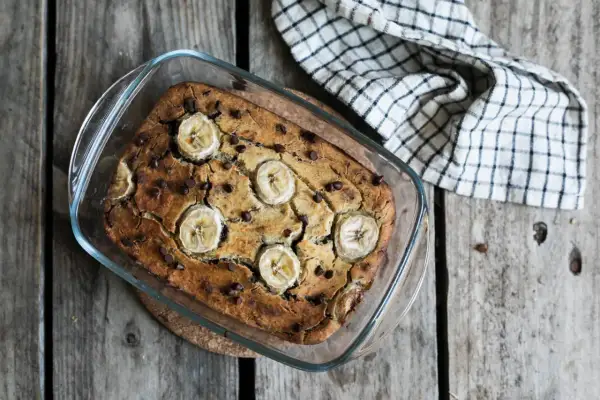 Un délicieux banana bread sans gluten, garni de rondelles de banane et de pépites de chocolat, sort tout juste du four.