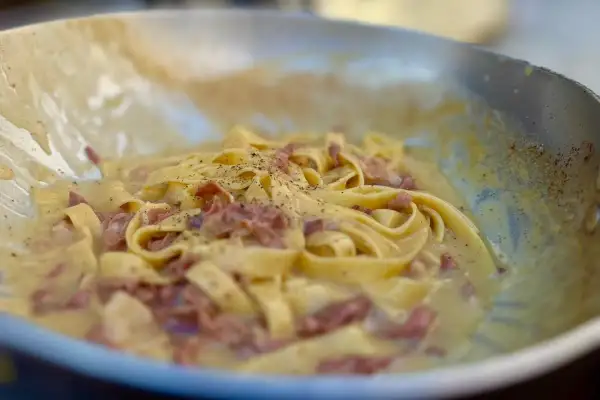 Fettuccine alla papalina crémeux et poivré, servi dans une poêle.