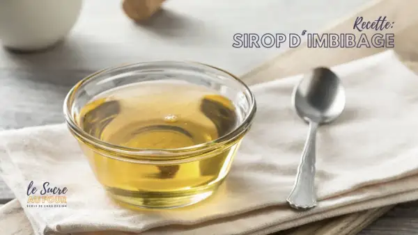 Un bol de sirop d'imbibage doré, parfait pour une génoise moelleuse. Une cuillère repose à côté.