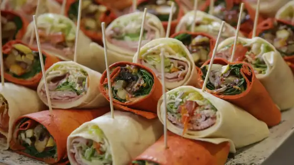 Plateau de wraps colorés, parfaits pour une recette facile et rapide. Garnitures variées visibles : légumes, charcuterie, sauce.