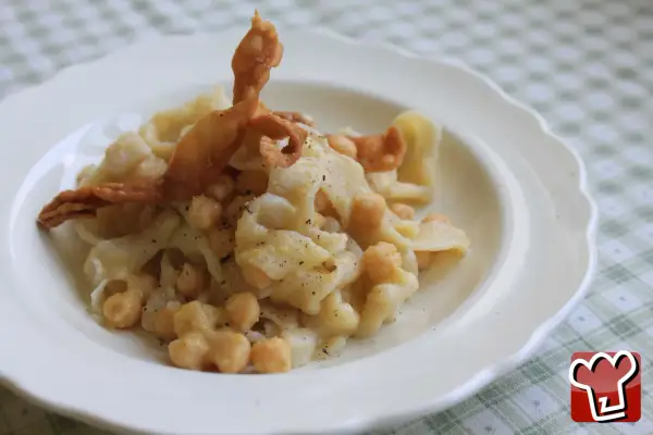 Un plat de ciceri e tria, pâtes fraîches et pois chiches, garni d'une feuille de pâte frite croustillante.