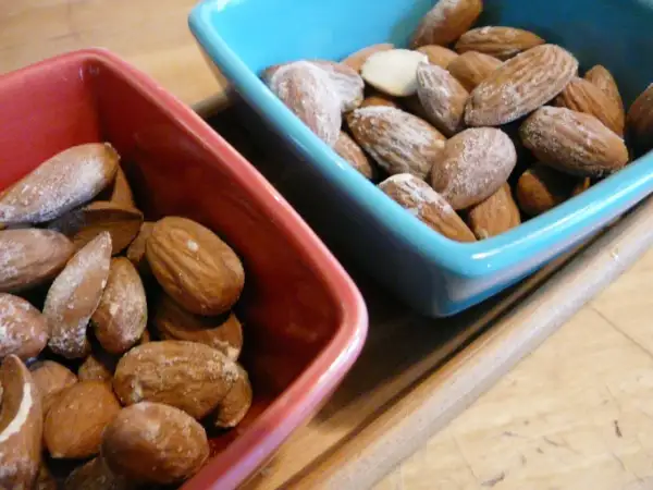 Deux bols, un rouge et un bleu, remplis d'amandes salées. Parfait pour un apéritif !