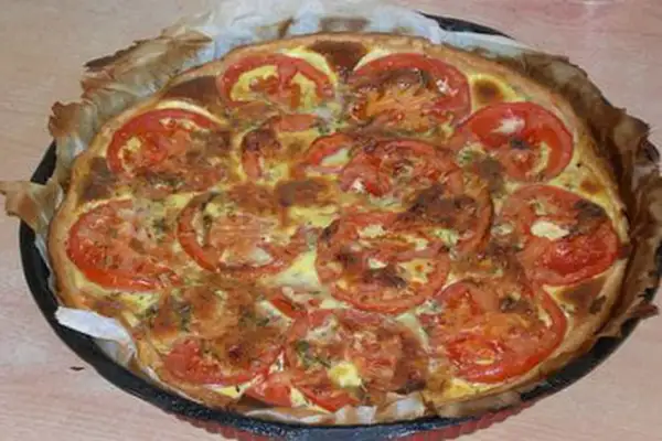 Tarte tomate thon moutarde dorée, garnie de rondelles de tomates fraîches et d'herbes. Un délice croustillant.