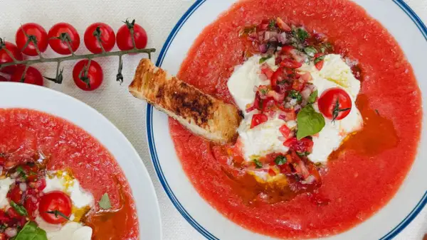 Soupe à la tomate rafraîchissante avec burrata, tomates cerises, oignons rouges, basilic et croûton grillé. Un délice estival.