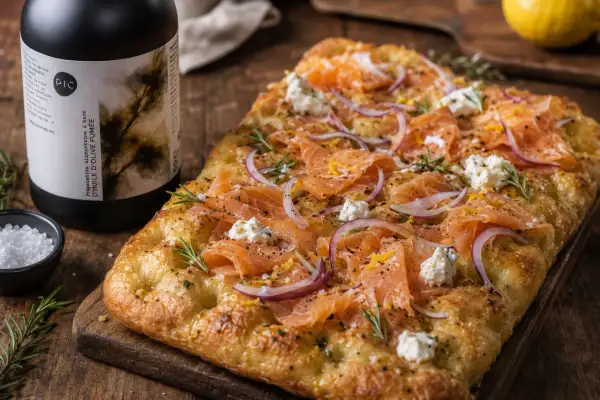 Délicieuse focaccia italiana garnie de saumon fumé, oignons rouges, fromage frais et romarin. Parfait pour un apéritif gourmand.